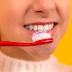 rapariga a escovar os dentes - Clínica Dentária de Oleiros