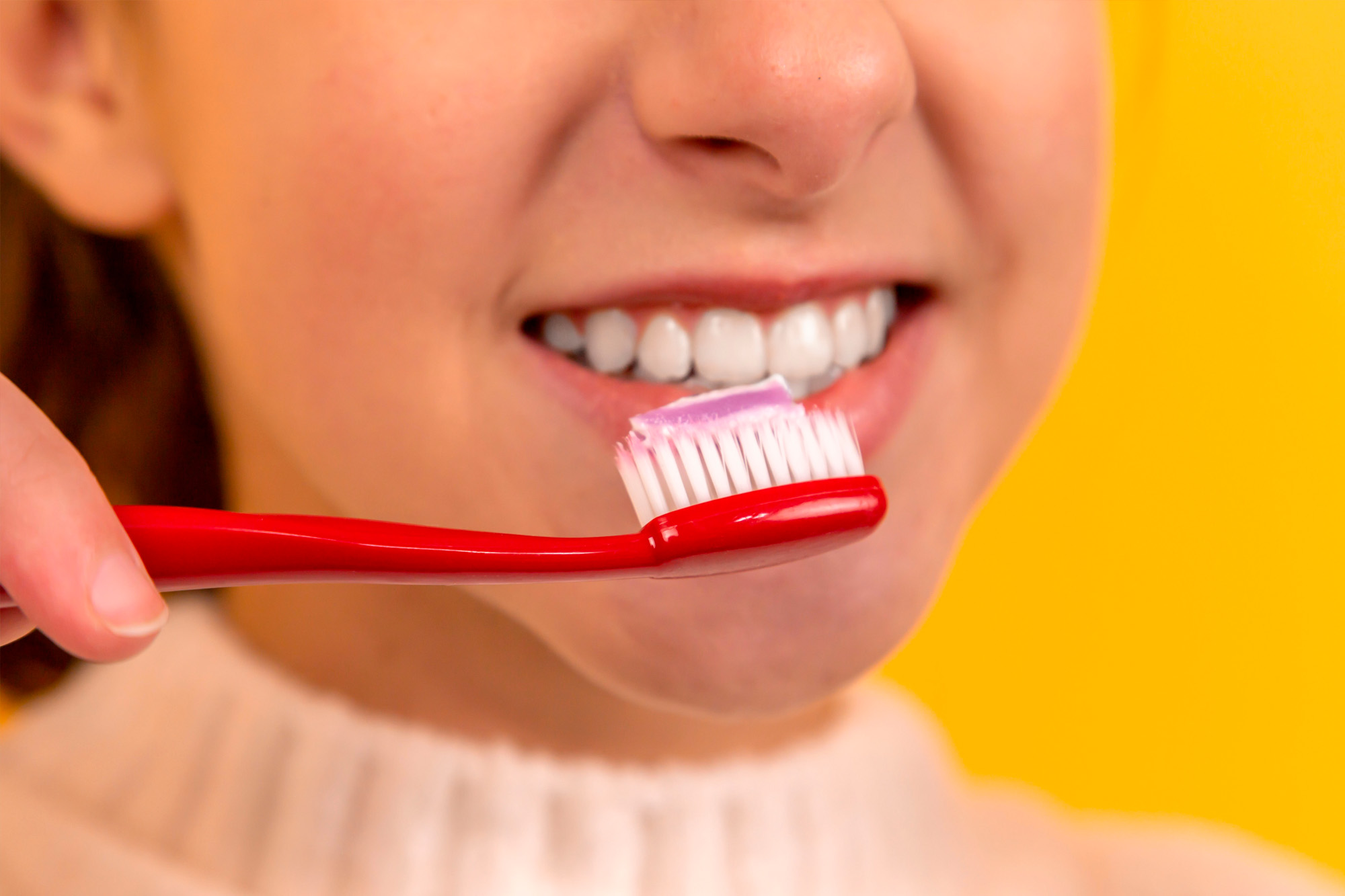 rapariga a escovar os dentes - Clínica Dentária de Oleiros
